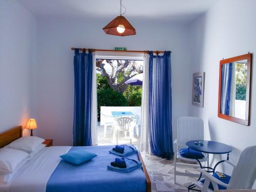 a bedroom with a bed and a patio with a table at Bungalows Ingrid in Tolo