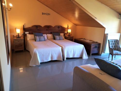 a large bedroom with two beds and a chair at Casa Mariñeira Lourdes in Cambados