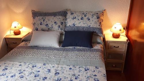 モグロにあるApartamento Playa Usilのベッドルーム1室(青と白のシーツとランプ2つ付)