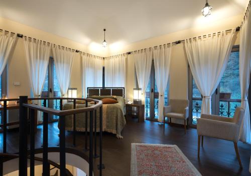 a bedroom with a bed and a table and chairs at Tufenkian Avan Dzoraget Hotel in Dzoraget