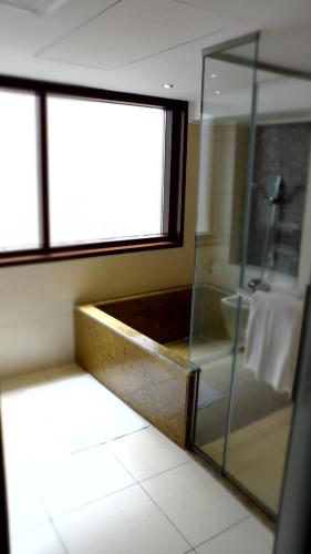 a bathroom with a glass shower and a tub at Mark Inn Hotel Deira in Dubai