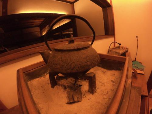 an old pot sitting on a table in a room at 古民家ゲストハウス ナマケモノ in Ōno