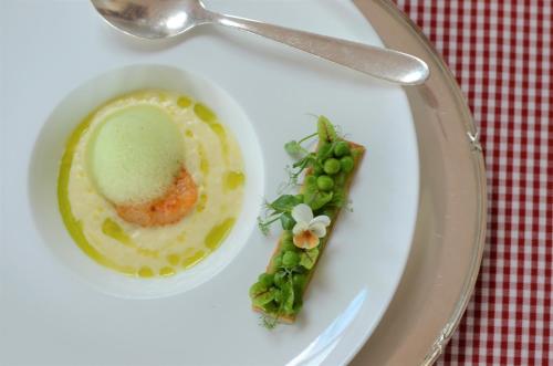 a white plate with a bowl of soup and asparagus at Ringhotel Alpenhof - Patchworkhotel in Augsburg