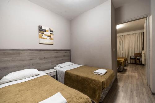 a hotel room with two beds and a table at Vergina Hotel in Thessaloniki