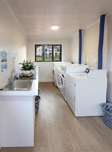 a laundry room with a washing machine and a sink at Brenton on Sea Cottages in Brenton-on-Sea