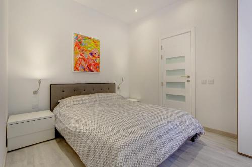 una camera da letto con un letto e un dipinto sul muro di Cozy Apartment in an Amazing Location a Sliema