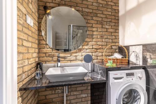 y baño con lavabo y lavadora. en Apartament Aristo Boutique en Białystok