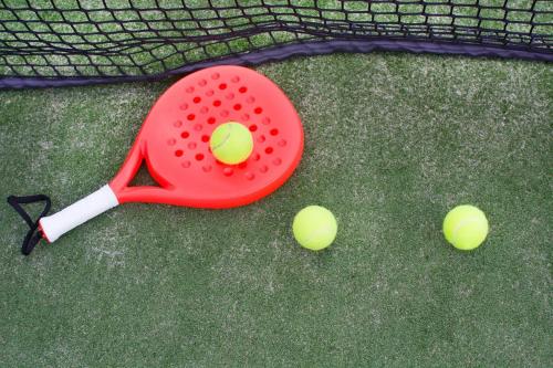 a tennis racket and two tennis balls on the ground at Casa de Mi Abuela Ribera del Duero in Roa