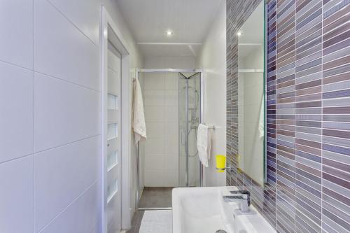 bagno bianco con lavandino e doccia di Cozy Apartment in an Amazing Location a Sliema