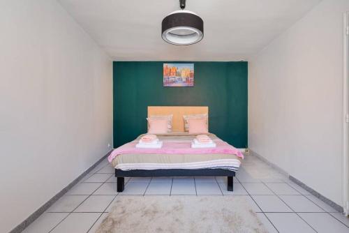 a bedroom with a bed with a green wall at Grand T2 50m2 - 10min Paris Orly - Jacuzzi - Fan in Alfortville