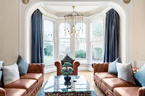 a living room with couches and a chandelier at The Heaton at Claremont Serviced Apartments in Leeds