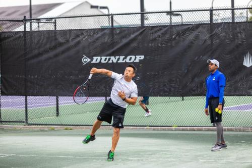 a man swinging a tennis racket on a tennis court at Legacy Hotel at IMG Academy in Bradenton