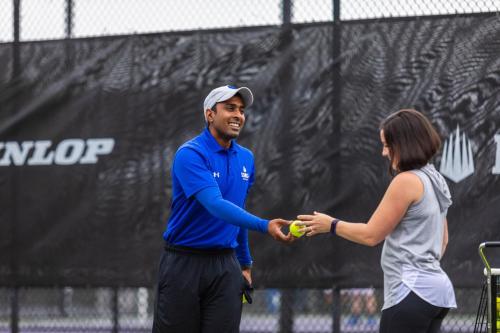 a man and a woman shaking hands on a tennis court at Legacy Hotel at IMG Academy in Bradenton
