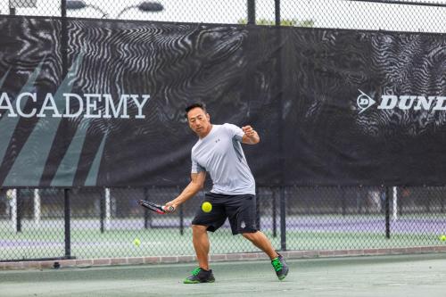 a man hitting a tennis ball with a racket at Legacy Hotel at IMG Academy in Bradenton