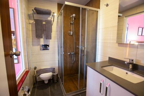 a bathroom with a shower and a toilet and a sink at HMA Hotel & Suites in Alanya