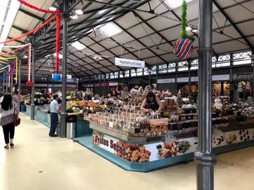 a farmers market with people walking around a store at Two bedroom apartment near beach and Casino in Figueira da Foz
