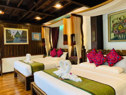 a hotel room with three beds with flowers on them at Hongkhao Village in Chiang Mai