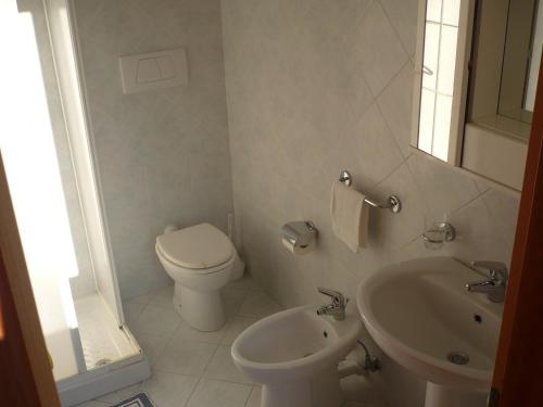 een witte badkamer met een toilet en een wastafel bij Zi Bak in Ischia