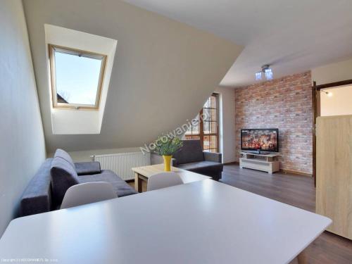 a living room with a white table and a brick wall at Fajny Apartament w Karpaczu in Karpacz