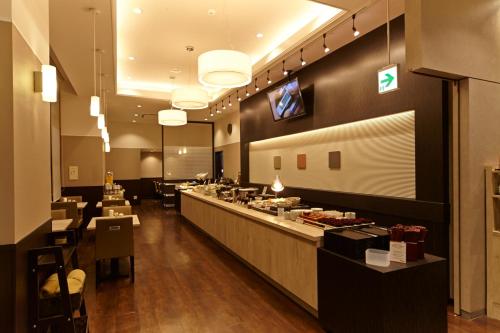 a restaurant with a long counter with a buffet at Dormy Inn Express Sendai Hirose Dori in Sendai