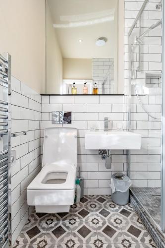 a white bathroom with a toilet and a sink at The Thoresby at Claremont Serviced Apartments in Leeds