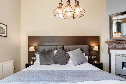 a bedroom with a large bed and a chandelier at The Thoresby at Claremont Serviced Apartments in Leeds