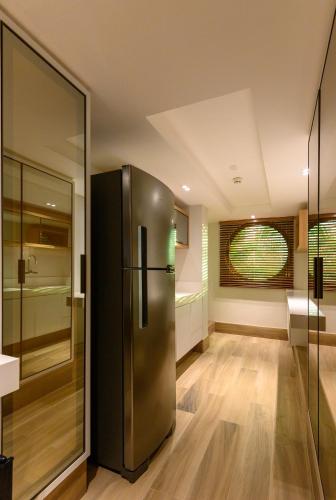 a kitchen with a stainless steel refrigerator in a room at Vogal Luxury Beach Hotel & SPA in Natal