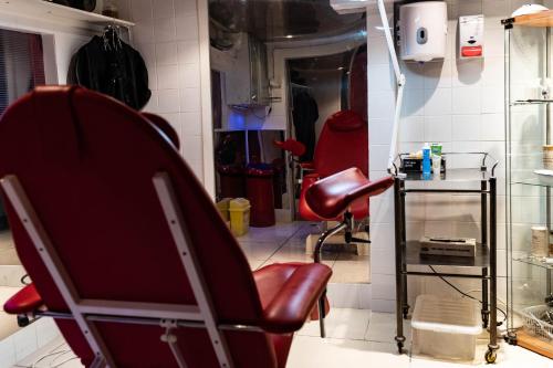 a salon with a red chair in a room at Brighton Erotic Boudoir in Brighton & Hove