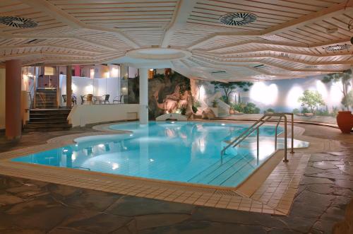 a large swimming pool in a hotel with a ceiling at Ringhotel Niedersachsen in Höxter