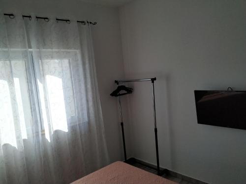 a bedroom with a window with a white curtain at Apartment Tomo in Ražanj
