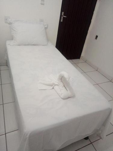 a pair of white shoes sitting on a white bed at Pousada Bela Vista de Mateiros in Mateiros