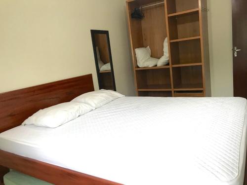 1 dormitorio con cama y estante para libros en Condominio residencial Ubatuba, en Ubatuba