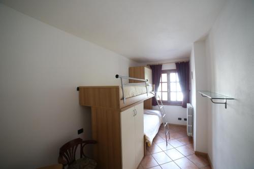 a small bedroom with a bed and a window at Residence Lucia in Bormio