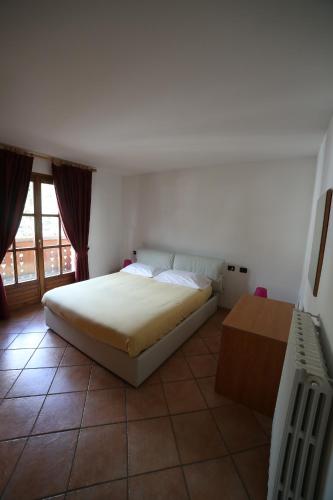 a bedroom with a large bed and a window at Residence Lucia in Bormio