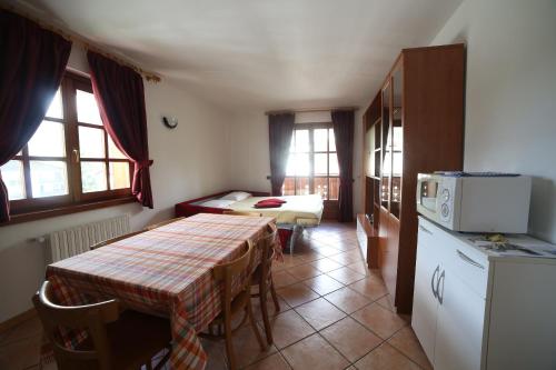 a room with a table and a kitchen with a table and a kitchen at Residence Lucia in Bormio