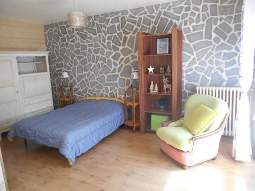 une chambre avec un lit et une chaise dans l'établissement Villa Les Mimosas, à Le Mont-Dore