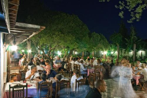 una folla di persone sedute ai tavoli di notte di Casa Saltara a Santa Teresa di Gallura