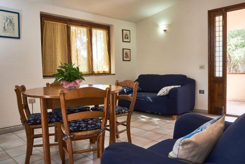 un soggiorno con tavolo, sedie e divano di Appartamento Fresia a Cala Gonone