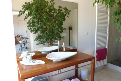 a bathroom with two white sinks on a wooden counter at Agora in Foussemagne