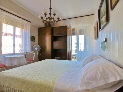 a bedroom with a large bed and a chandelier at Guest house Ribaric in Rab
