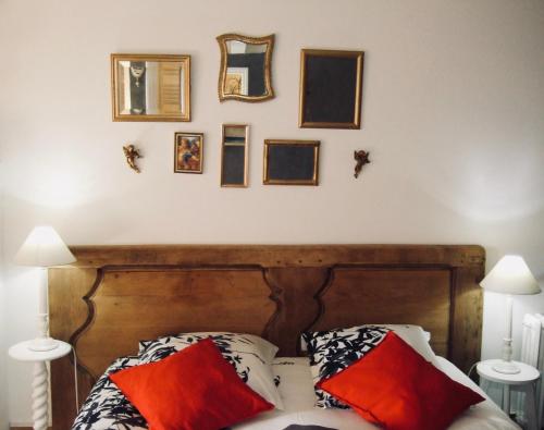 a bedroom with a wooden bed with pillows and mirrors at Maison d'hôtes l'Angevinière, chambre des Anges proche Mont-Saint-Michel in Saint-Laurent-de-Terregatte