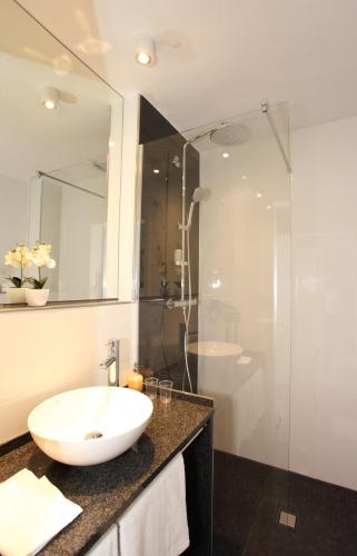 a bathroom with a white sink and a shower at Hotel Apartments 73 - Serviced Apartments in Neu Wulmstorf
