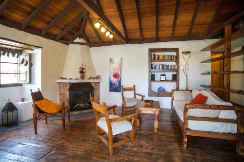 een woonkamer met een open haard en stoelen bij Casa Ruth in Los Llanos de Aridane