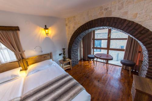 a bedroom with a bed in a room with a brick wall at Heraklis Hotel in Berat