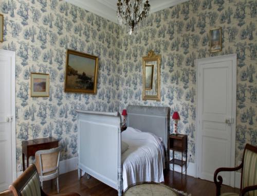 1 dormitorio con papel pintado azul y blanco en Château de Villars, en Villeneuve-sur-Allier