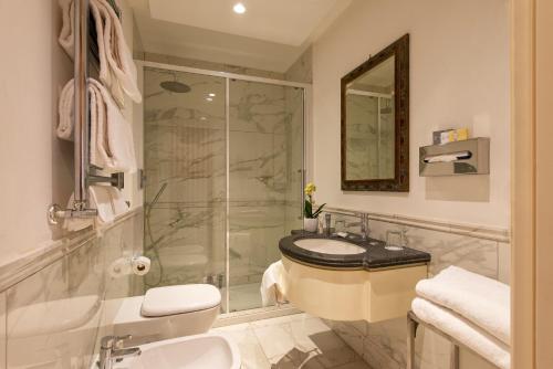 a bathroom with a shower and a sink and a toilet at Atlante Star Hotel in Rome