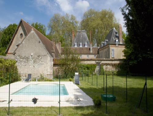 an old house with a swimming pool in front of it at Château de Villars in Villeneuve-sur-Allier