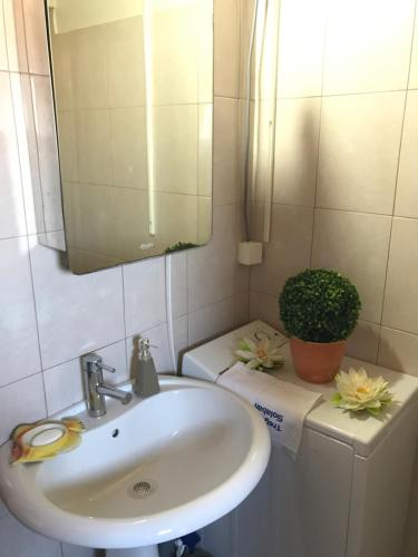 La salle de bains est pourvue d'un lavabo, d'un miroir et de toilettes. dans l'établissement Kucica na Adi Bojani, à Ulcinj