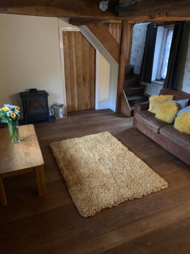 a living room with a couch and a rug at The griffin cottage in Ludlow