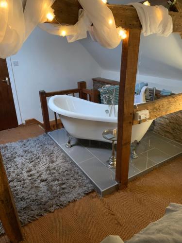 La salle de bains est pourvue d'une baignoire et d'un lavabo. dans l'établissement The griffin cottage, à Ludlow